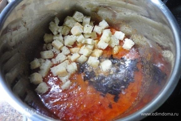 К томатам добавить чеснок с базиликом и нарезанный на кусочки белый черствый хлеб. Перемешать, посолить, поперчить и потомить минут 10.