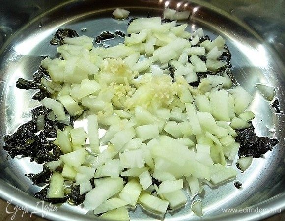 Добавляем в сковороду мелконарезанные репчатый лук и чеснок, перемешиваем и обжариваем до прозрачности. Убираем сковороду с огня.