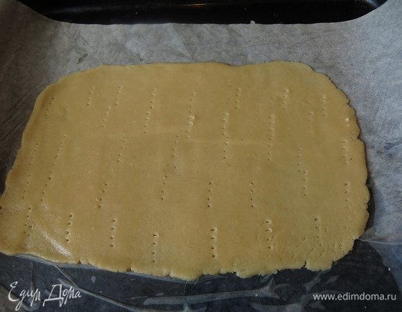 Раскатываем тесто в прямоугольник, прокалываем и выпекаем 5–7 минут при 200–220°C.