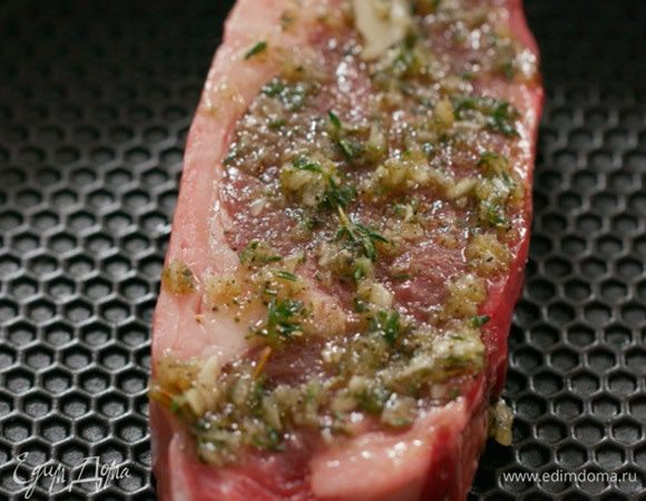 Стейк смазать половиной заправки, выложить на разогретую сковороду-гриль несмазанной стороной вниз и жарить 2–3 минуты, затем мясо перевернуть, смазать обжаренную сторону оставшейся заправкой и жарить еще 2–3 минуты.