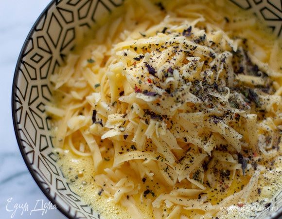 Яйца слегка взбить, смешать с натертым сыром (100 г) и специями.