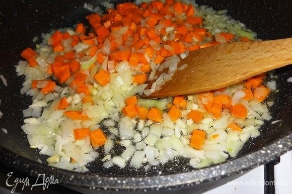 Добавить морковь к луку и чесноку и продолжать обжаривать еще несколько минут.