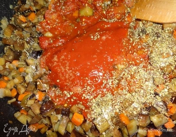 Посыпать содержимое сковороды итальянскими травами, перцем, солью, сахаром. Перемешать овощной соус и потушить еще несколько минут, помешивая.