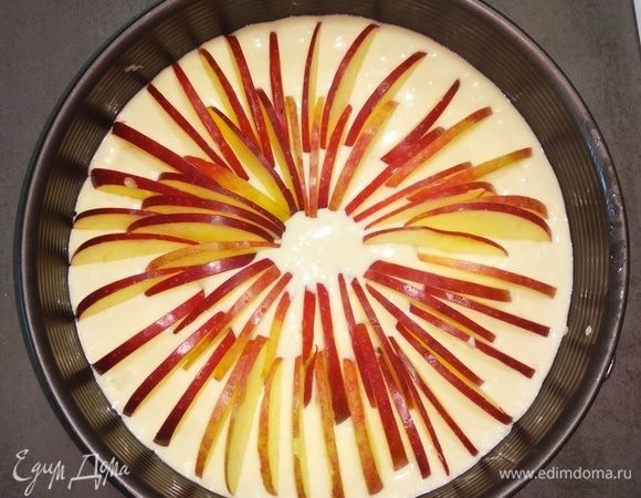 Выливаем тесто в смазанную маслом форму для выпекания (моя форма 26 см). И вставляем «ребрышком» нарезанные яблоки по кругу, начиная от края формы и оканчивая серединой.