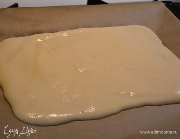 Вылить тесто на противень, выстланной пекарской бумагой. Разровнять, чтоб получился прямоугольник. Запечь при температуре 180°C в течение 15 минут.