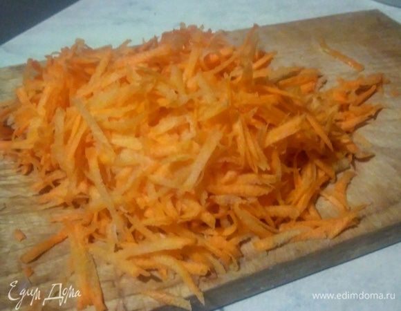 Морковь трем на крупной терке, добавляем к луку и тушим еще 7 минут.