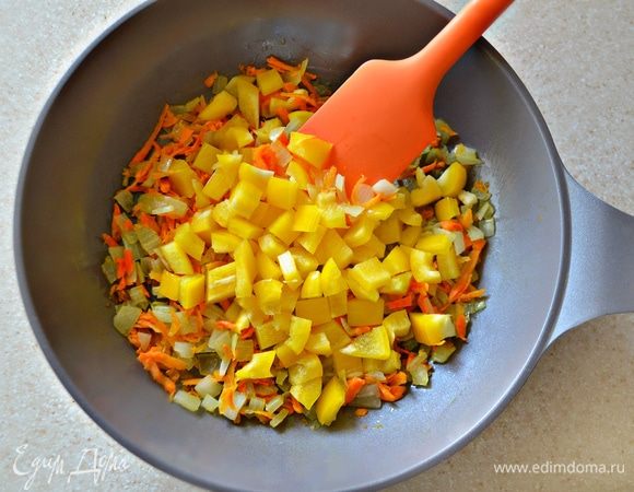 На оливковом масле слегка обжарить лук, добавить тертую морковь и нарезанный кубиками болгарский перец. Посолить, поперчить, добавить щепотку сухого базилика. Тушить, периодически помешивая, в течение 10 минут.