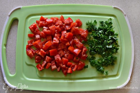 С помидоров снять кожицу и нарезать мелкими кубиками. Зелень петрушки мелко порубить и вместе с помидорами добавить к овощам. Тушить все вместе еще 5 минут.