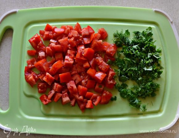 С помидоров снять кожицу и нарезать мелкими кубиками. Зелень петрушки мелко порубить и вместе с помидорами добавить к овощам. Тушить все вместе еще 5 минут.