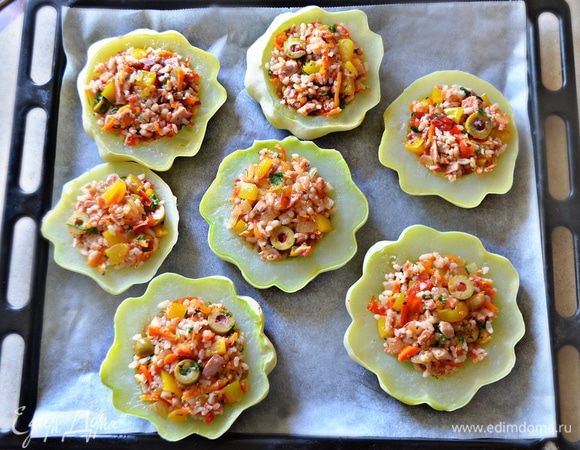 Противень застелить пергаментом, немного смазать оливковым маслом и выложить половинки патиссонов. Наполнить патиссоны начинкой и поставить в разогретую до 180°C духовку примерно на 15 минут.