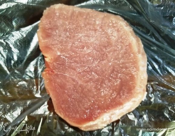 Мясо нарезаем на порционные куски и отбиваем между двумя слоями пищевой пленки.