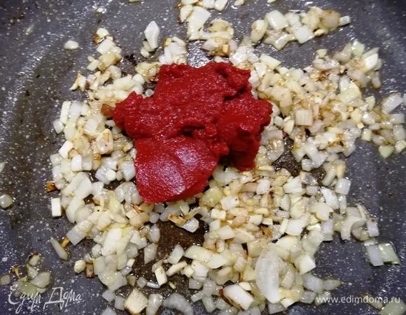Пока запекается мясо, приготовим соус. Обжариваем лук и чеснок на оливковом масле. Добавляем томатную пасту ТМ «Помидорка», обжариваем вместе 2–3 минуты.