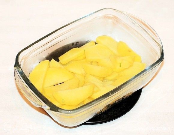 Дно формочки смазать растительным маслом и выложить дольки картофеля.