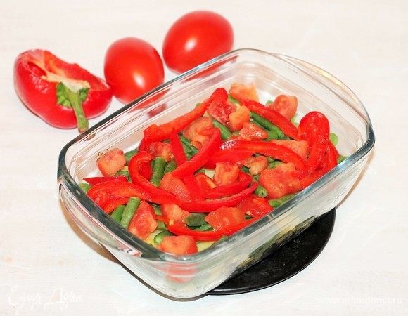 На фасоль кладем дольки помидоров и нарезанный соломкой сладкий перец. Посыпать приправой для овощей и паприкой.