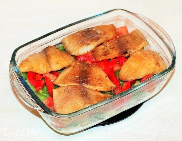 На овощи раскладываем кусочки рыбы и поливаем медовым соусом. 1–2 ст. л. соуса оставляем. Закрываем форму с рыбой фольгой (не плотно) и отправляем в хорошо разогретую до 180°C духовку на 20 минут.