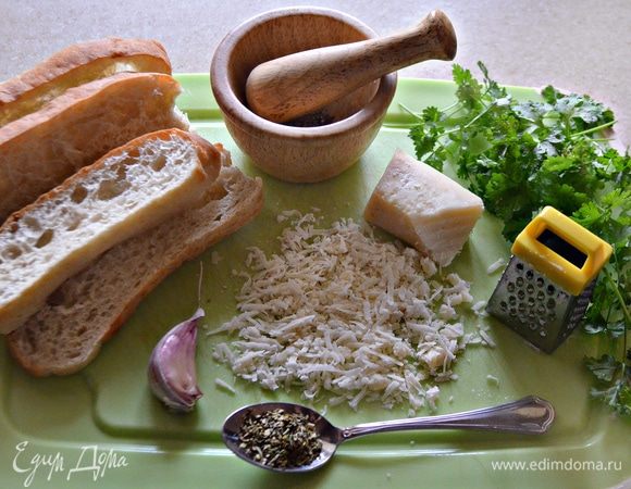 Кусочки белого хлеба (у меня — чиабатта) необходимо заранее подсушить, после чего поместить в целофановый пакет и пройтись несколько раз скалкой до получения крупной крошки. Пармезан натереть, чеснок измельчить. Зелень петрушки мелко порубить.