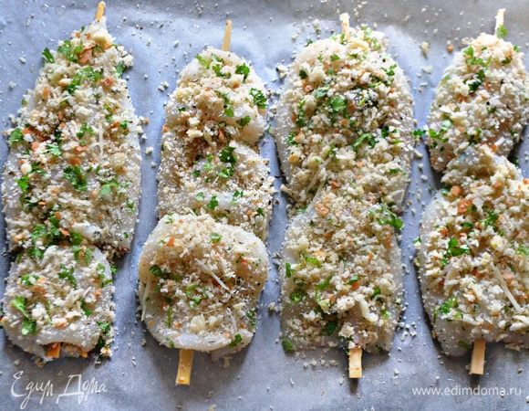 Филе кальмара смазать оливковым маслом, обвалять в полученной смеси и нанизать на шпажки, предварительно замоченные на 15 минут в воде. В этот раз я использовала палочки для суши и роллов. Выложить шпажки с кальмарами на противень, застеленный пергаментом и смазанный немного оливковым маслом. Остатки панировки распределите по кальмарам, немного придавливая. Запекайте кальмары 25–30 минут в разогретой до 180°C духовке.
