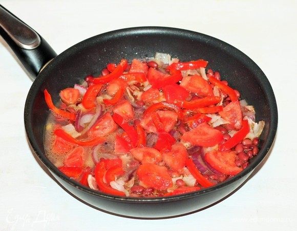 Добавить в сковороду нарезанный соломкой печеный перец, четвертинки помидоров и томатный кетчуп, посолить и поперчить.