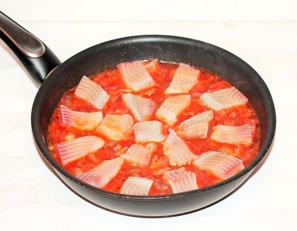 Выложить кусочки рыбы в соус, посыпать приправой, накрыть сковороду крышкой и готовить рагу на медленном огне минут 20. Добавить в рагу рубленую кинзу (по вкусу) и перемешать.