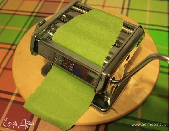 Тесто отдохнуло, начинаем делать пасту. Можно раскатать тесто скалкой до толщины около 1 мм и затем ножом нарезать на полосочки. А я воспользуюсь машинкой для пасты. Делим каждый шар теста на 4 части. Берем одну часть и слегка раскатываем ее скалкой. Потом пропускаем тесто через машинку. Так раскатываем все тесто.