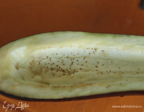 У баклажанов ложкой достать мякоть, нарезать ее и добавить к начинке.