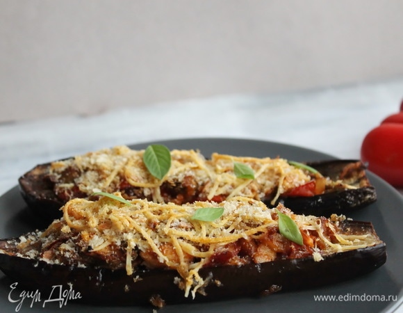 Начинить баклажаны курино-овощной начинкой. Смешать тертый пармезан и хлебные крошки и щедро посыпать баклажаны. Готовить в разогретой до 180°C духовке 20–25 минут. Подавать баклажаны горячими)