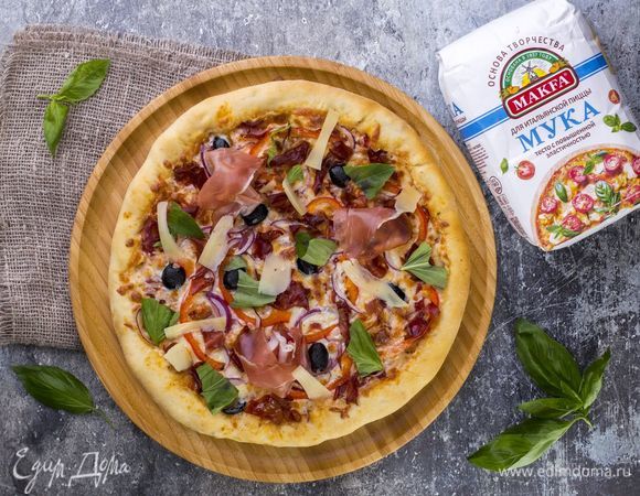 Запекайте пиццу в духовке, разогретой до 200°C, в течение 25 минут. На готовую пиццу выложите нарезанный слайсами пармезан, немного базилика и пармскую ветчину. Приятного аппетита!