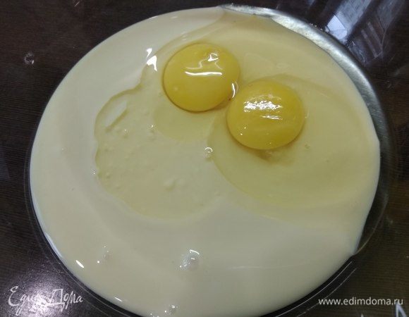 Разогреваем духовку до 180°C. В миске соединяем сгущенку и яйца, взбиваем венчиком до однородности.