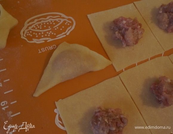 Соединить края квадратов и сформировать треугольник. Если края теста плоха слепляются, то краешки можно слегка смочить водой (совсем капельку).