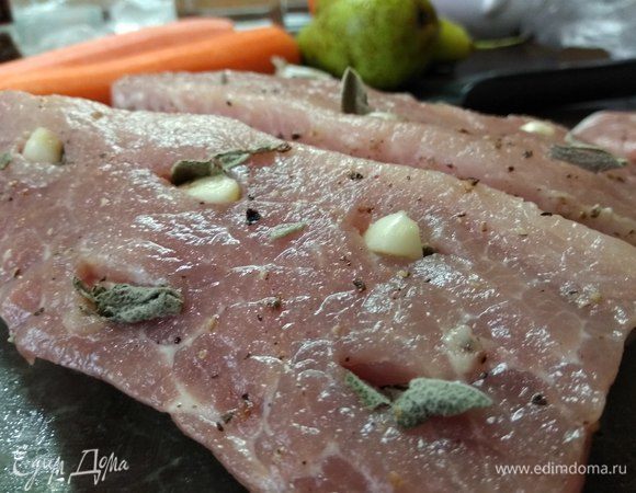 Берем часть свинины, пригодную для запекания. Лучше всего вырезку. Если кусок крупный, то разрезаем его на 2 части. Очищаем от пленок и жира, смазываем оливковым маслом и натираем солью. Делаем ножом надрезы по всей поверхности и кладем в них разрезанные на несколько частей зубчики чеснока и целые листики шалфея.