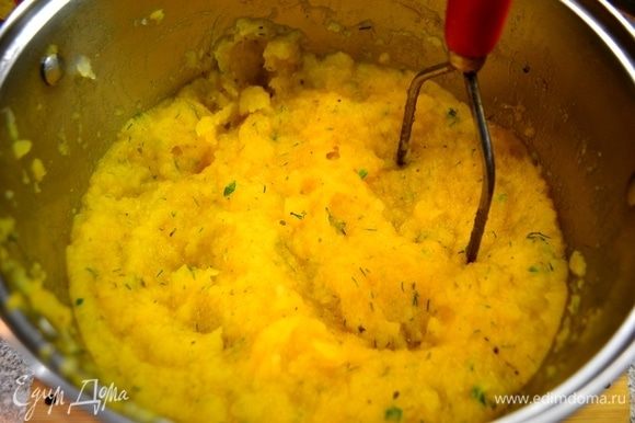 Толкушкой разминаем овощи в пюре. В пюре добавляем желток, тертый сыр пармезан и перемешиваем.