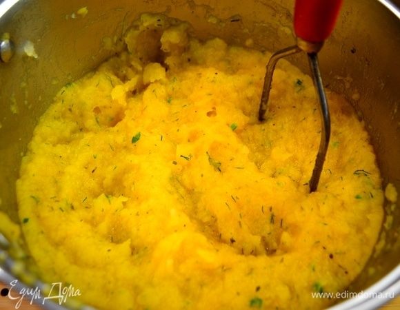 Толкушкой разминаем овощи в пюре. В пюре добавляем желток, тертый сыр пармезан и перемешиваем.