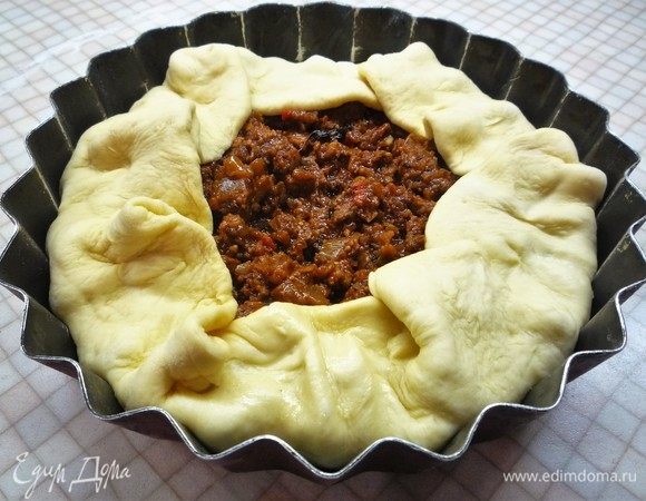 Поверх теста выкладываем мясо со специями, края теста заворачиваем к середине формы.