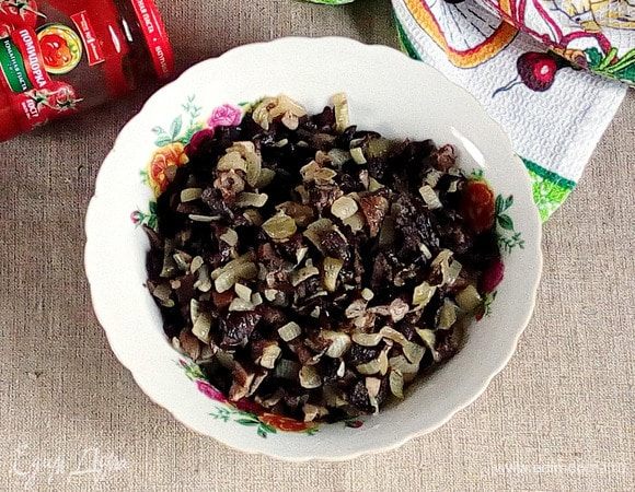 В предварительно разогретой сковороде на оливковом масле обжарить до легкого румянца репчатый лук, добавить грибы и довести до полной готовности. Начинку остудить.