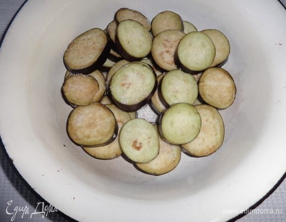 Кружки баклажанов сложить в миску слоями. Каждый слой немного посолить. Оставить баклажаны на 30 минут.