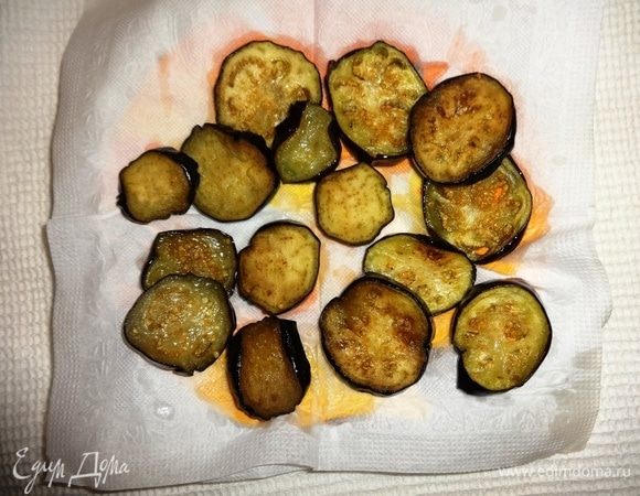 Обжаренные кружки баклажанов выложить на бумажное полотенце для впитывания излишков масла.