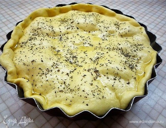 Раскатываем оставшееся тесто и выкладываем его поверх начинки. Смазываем верх пирога оливковым маслом и посыпаем базиликом. Даем пирогу подойти еще 15–20 минут.