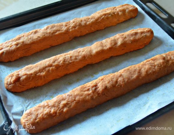 Сформируйте из теста три батончика и выложите на смазанный оливковым маслом пергамент, перенесите на противень. Выпекайте батончики в разогретой до 180°C духовке в течение 20 минут.