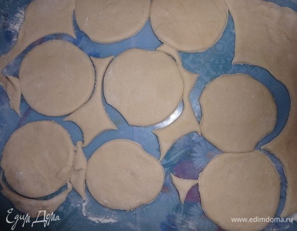 С помощью стакана вырезать заготовки для вареников. Остатки теста слепить в комок, немного помесить и снова раскатать.