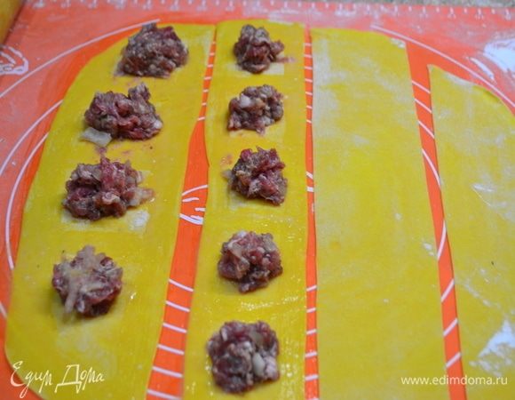 Для начинки смешать свиной и говяжий фарши, добавить мелконарезанный лук, специи, соль, по желанию — зелень. Дать настояться, пока готовим тесто. Готовим тесто: в муку добавляю соль, оливковое масло, яйца, замешиваю тесто. Это долгий процесс вымешивания. Если желтки оказались недостаточно яркими, можно слегка подкрасить тесто куркумой. Когда тесто станет пластичным, оно готово. На минут 30 убираю его в холодильник. Раскатываю тесто в пласт толщиной 2 мм и режу на полоски. Вариантов лепки много. Можно прям на полоски выложить начинку или на разделенные квадраты. Хорошо, если есть машинка для раскатки теста, это явно облегчит ваш труд! Но я пока работаю скалкой.