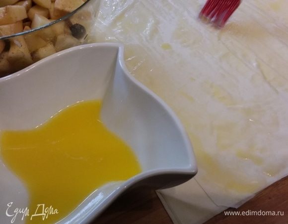 Яблоки очистить и мелко нарезать. Смешать с ягодами, сбрызнуть соком лимона и посыпать сахаром. Сливочное масло растопить. Разложить листы теста фило, смазать верхний слой маслом, выложить 1/8 часть начинки по краю и завернуть в рулет. Рулет скрутить в улитку и выложить в форму для запекания, предварительно смазанную маслом. Форму следует выбирать цельную, чтобы заливка не вытекала.