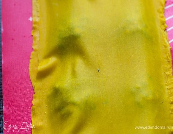 Накрыть вторым пластом теста и вырезать равиоли формочками или специальным ножом, или стаканом, придавливая края вилкой.