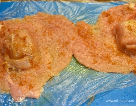Замороженное масло разрезать пополам. Куриное филе посолить и поперчить. На середину большого филе уложить замороженное масло, накрыть маленьким филе. Плотно обернуть масло куриным филе, чтобы не было просветов.