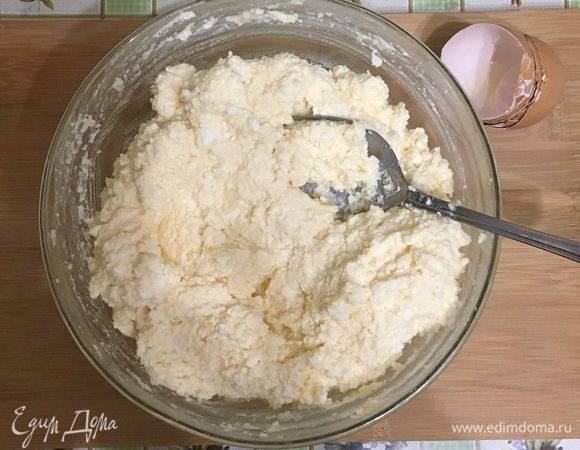 Курагу и изюм промойте, залейте кипящей водой и оставьте на одну минуту. Выложите в миску творог, манку, яйца и сахар. Тщательно перемешать все ингредиенты.