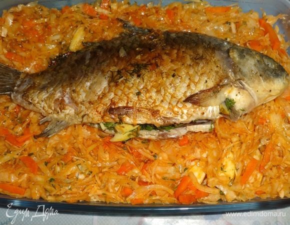 Положить вторую часть капусты. На капусту выложить фаршированного карася. Поставить форму в духовку, разогретую до 180°C, на 35–40 минут.