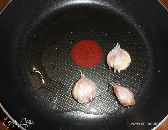 Дольки чеснока, не очищая от шкурки, раздавить плоской стороной ножа. На другую сковороду налить оставшееся оливковое масло, выложить чесночные дольки. Хорошо прогреть, затем осторожно (!) добавить 80 мл сухого белого вина, дать закипеть.