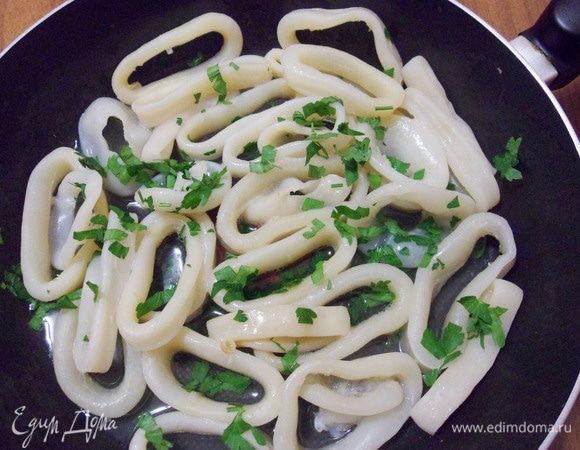 Посолить, поперчить, посыпать зеленью петрушки. Готовить 4 минуты на сильном огне. Главное здесь — не передержать кальмары! Они должны остаться мягкими.