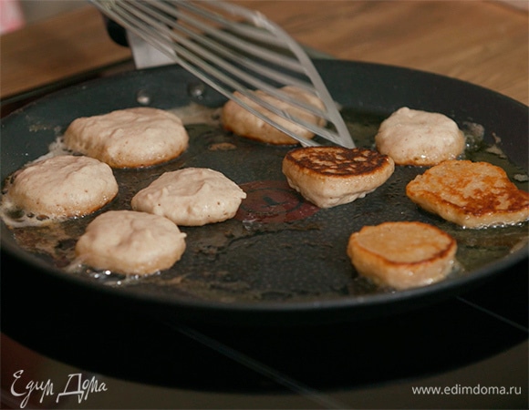 Разогреть в сковороде оливковое и оставшееся сливочное масло и пожарить из теста маленькие блинчики или оладушки, на часть из них выложить свекольный топинг и половинки вареных яиц, на остальные —топинг из огурца и икру.
