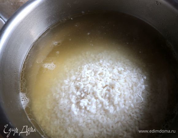 В горячий бульон опустить рис. Поставить на огонь. Варить примерно 12 минут или чуть больше, периодически помешивая. В ходе приготовления проверить на соль, посолить при необходимости. Можно кипящий бульон добавлять к рису частями. Рис должен впитать весь бульон.