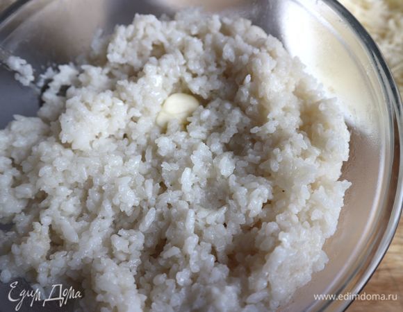 Переложить рис в миску, чтобы остановить процесс прогревания. К немного остывшему рису добавить кусочек сливочного масла (15 г).